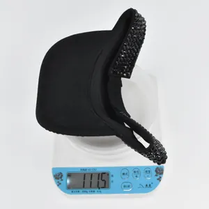 Digital scale showing the lightweight 111.5g weight of this black rhinestone sun visor