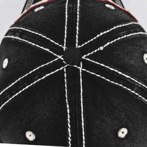 Macro-opname van vintage zwarte denim pet met witte kruissteken en geborduurde sterren