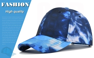 Macro detail of blue tie-dye baseball cap fabric showing six-panel structure and curved brim
