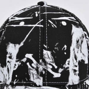 Close-up of black cotton baseball cap showing detailed anime-style eye print and stitching