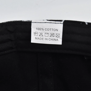 Detail shot of the 100% cotton wash label and care instructions inside the black cap
