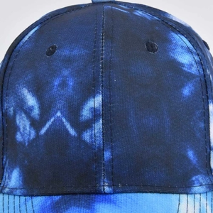 Detailed close-up showing the blue tie-dye fabric texture and stitching on the baseball cap