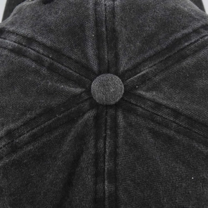 Close-up of vintage corduroy texture and button on top of this dark grey baseball cap