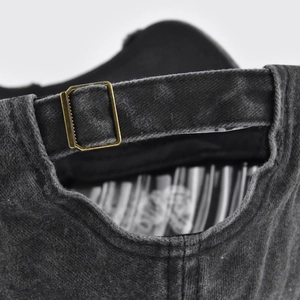 Close-up of the metal buckle adjustment and washed black cotton fabric on the baseball cap