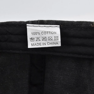 Detailed close-up of the 100% cotton care label and stitching on the black baseball cap