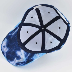Detailed view of the six-panel interior structure and blue tie-dye fabric of the baseball cap