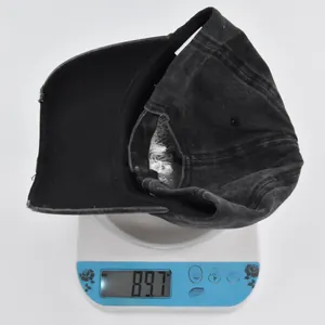 Detail view of washed cotton baseball cap weighing 89.7g on digital scale