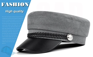 Detail of grey twill sailor cap featuring a black leather brim and silver crest button