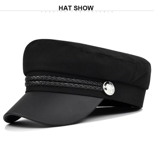 Detail of vintage navy hat featuring braided rope trim and silver embossed metal button