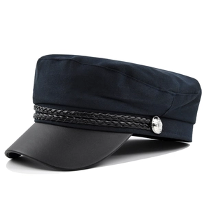 Detail of navy fiddler cap with woven rope trim and silver embossed metal button
