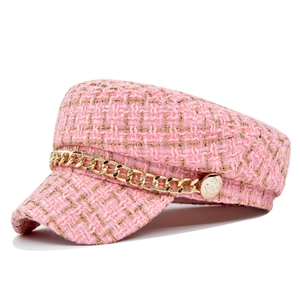 Detail of pink tweed newsboy cap with metallic gold chain and embossed buttons