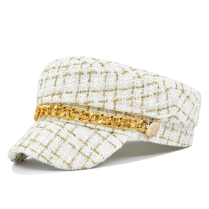 Close-up of white tweed fabric texture and gold chain on the fashionable baker boy hat