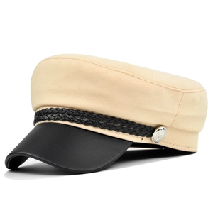 Close-up of beige canvas cap with black leather brim and silver crest button detail