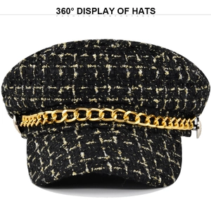 Detail view of black bouclé plaid newsboy hat with gold chain and woven tweed texture