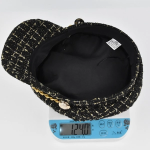 Detailed view of plaid tweed newsboy cap weighing 124g with cotton polyester label