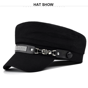 Detail of black military cap with rhinestone studded leather strap and metal buckle