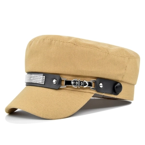 Detail of khaki military cap featuring rhinestone studded leather strap and silver buckle