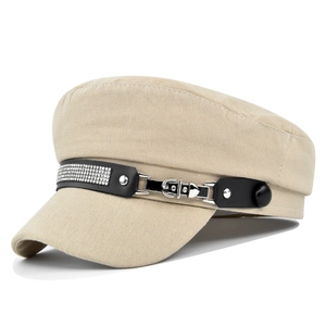 Detail of beige newsboy hat showing rhinestone belt buckle and woven fabric texture