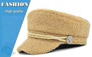 Detail of camel sherpa navy hat featuring braided rope and embossed metal button
