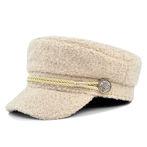 Detail of beige fleece newsboy hat featuring golden braided rope and metallic buttons