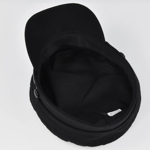 Detail view of the black newsboy cap interior showing the lining and white wash label