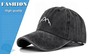 Detailed close-up of a washed black baseball cap with white 3D mountain embroidery.