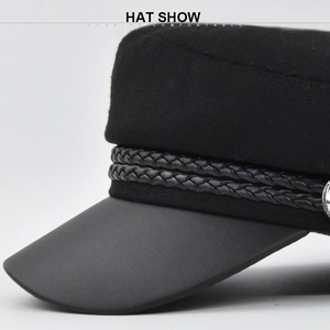 Detail of wool fabric and leather brim on navy baker boy hat with metal buttons