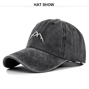 Close-up of vintage washed cotton baseball cap with 3D mountain embroidery and curved brim
