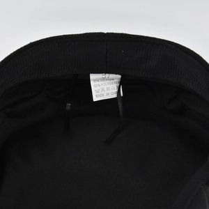 Detail view of cotton blend newsboy cap inner lining with washing label and size tag