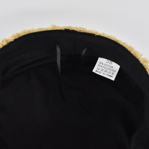 Close-up of fluffy khaki fleece baker boy hat lining with size 58 label and sweatband