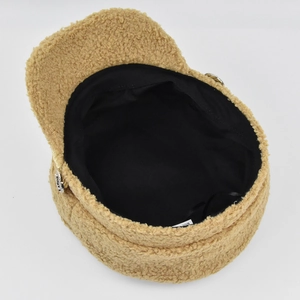 Close-up of camel faux shearling newsboy hat showing interior lining and soft fuzzy texture