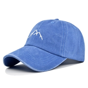 Detail of white mountain embroidery on washed blue cotton vintage baseball cap