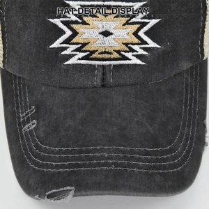 Macro view of geometric embroidery and washed fabric detail on the grey baseball cap