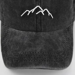 Close-up of mountain embroidery on black washed denim baseball cap with sharp texture