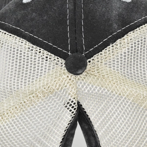 Detail of vintage trucker hat showing washed black fabric and breathable mesh texture