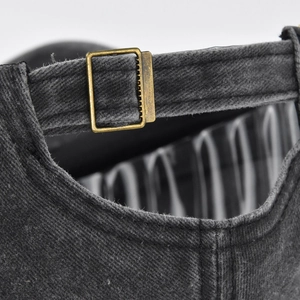 Detailed macro view of the adjustable antique bronze metal buckle on a washed cotton cap