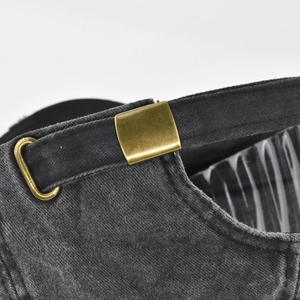 Detailed macro view of the vintage washed cotton baseball cap with bronze metal adjustment buckle