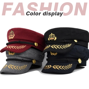 Détail de la broderie d'épis de blé dorés et de l'insigne couronne sur casquettes