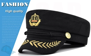 Détail de la broderie couronne dorée et du bouton ancre sur la casquette de marin noire