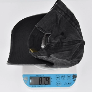 Detail view of washed vintage cotton baseball cap on scale weighing 87.9 grams