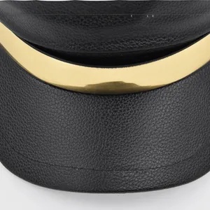Detail of black pebbled leather texture with a shiny gold metallic band on the navy hat