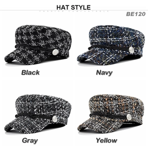 Detail view of four tweed newsboy hats with braided ropes and metal buttons