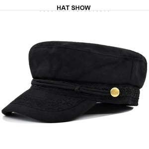 Détail d'un chapeau marin noir en laine avec broderie en dentelle et bouton doré