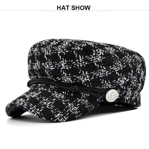 Detail of tweed newsboy cap with braided rope trim and silver anchor metal button