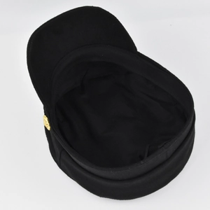 Vue détaillée d'une casquette de marin noire avec un bouton doré vintage en métal