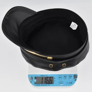 Detail shot of black PU leather baker boy hat showing its 116.6g lightweight design