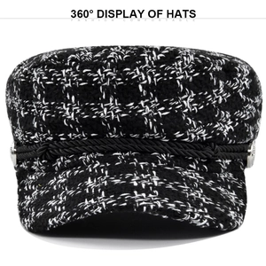 Detail of black and white plaid tweed newsboy cap with decorative rope and silver buttons