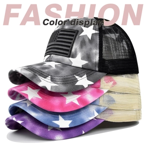 Detailed stack of US flag tie-dye ponytail trucker hats with breathable mesh backing