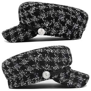 Detail view of the black and white tweed newsboy cap with nautical anchor metal buttons