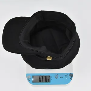 Détail intérieur d'une casquette marine avec bouton doré pesée sur une balance